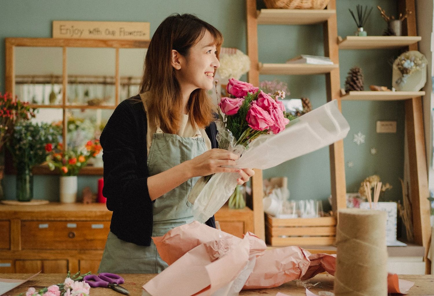 منسّقة الورد تحضّر باقة وردية داخل المحل