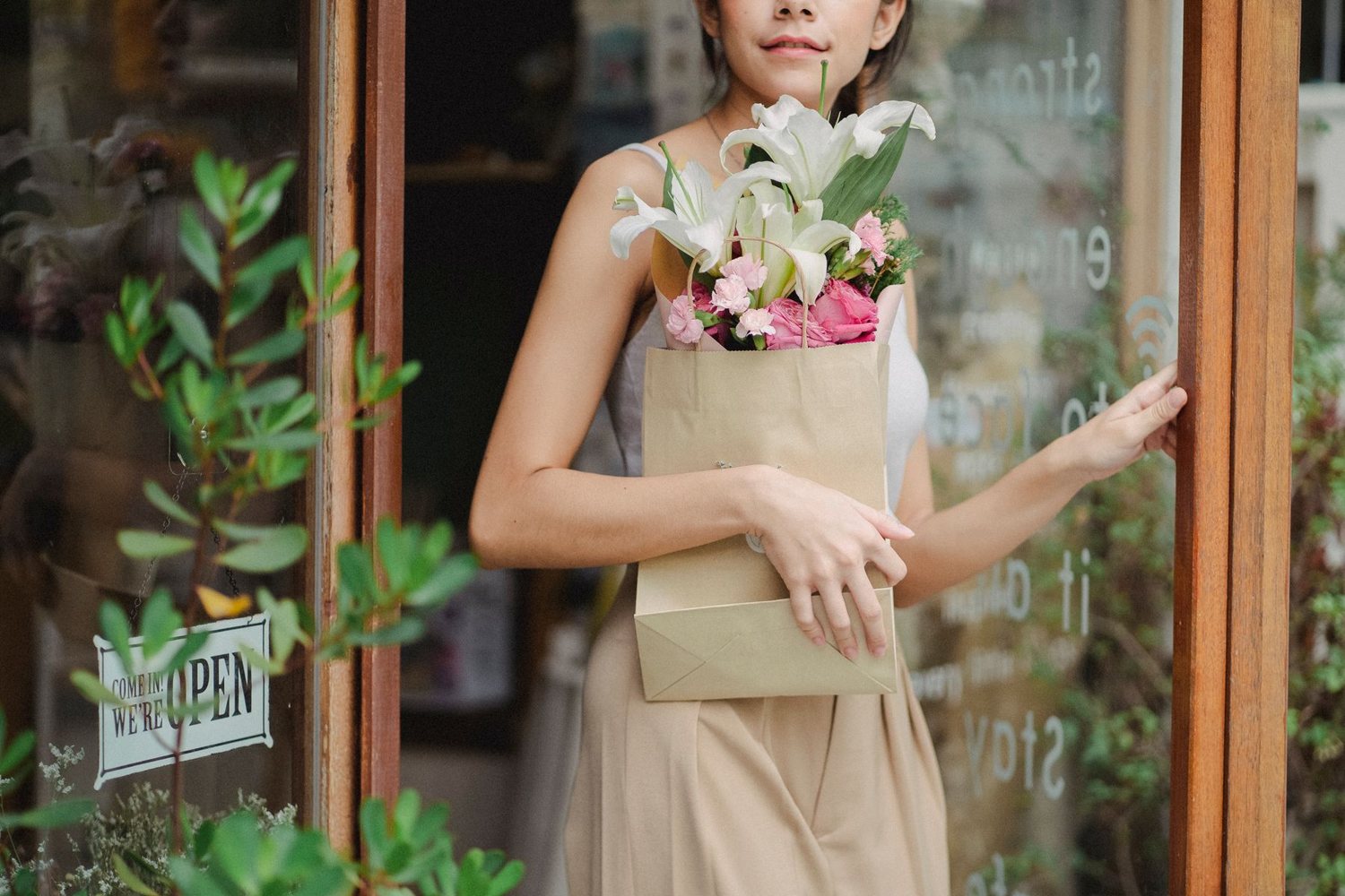 A bouquet of lilies in a paper bag at the shop door