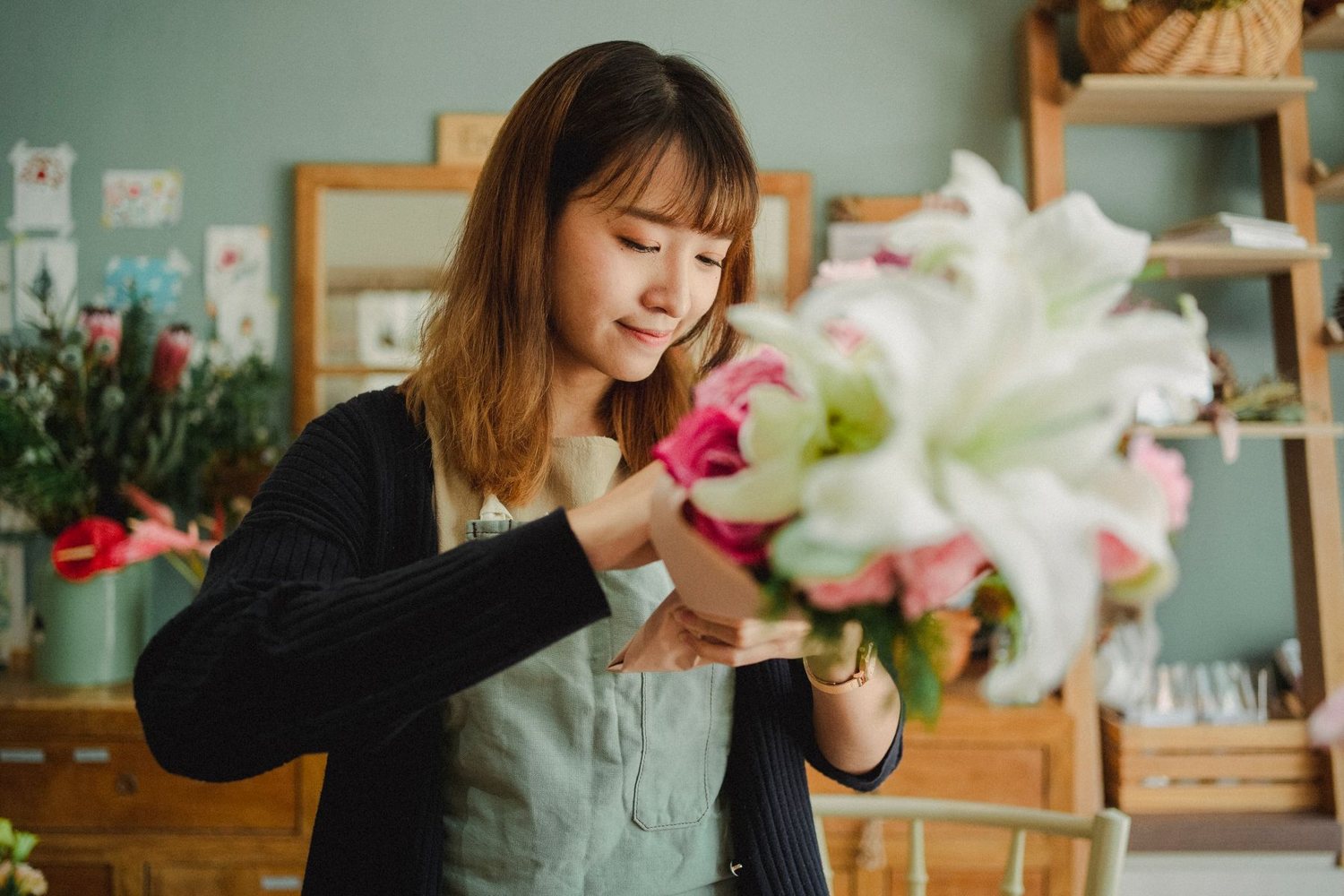 Florist placing white lilies in a bouquet