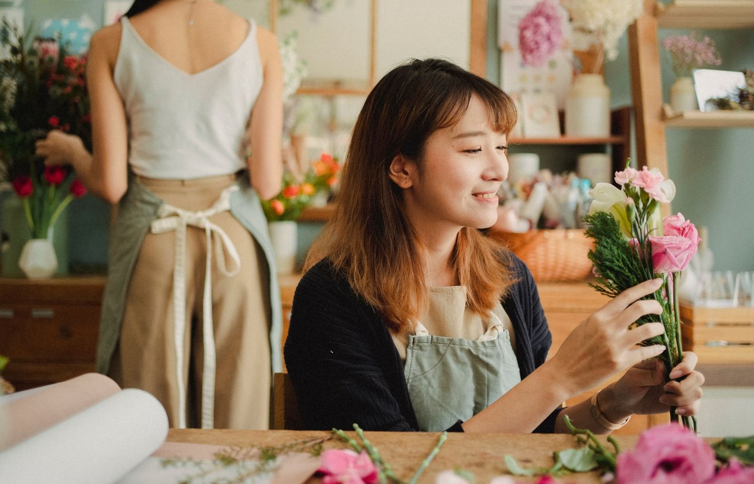 Florist smiling while preparing an order at the desk