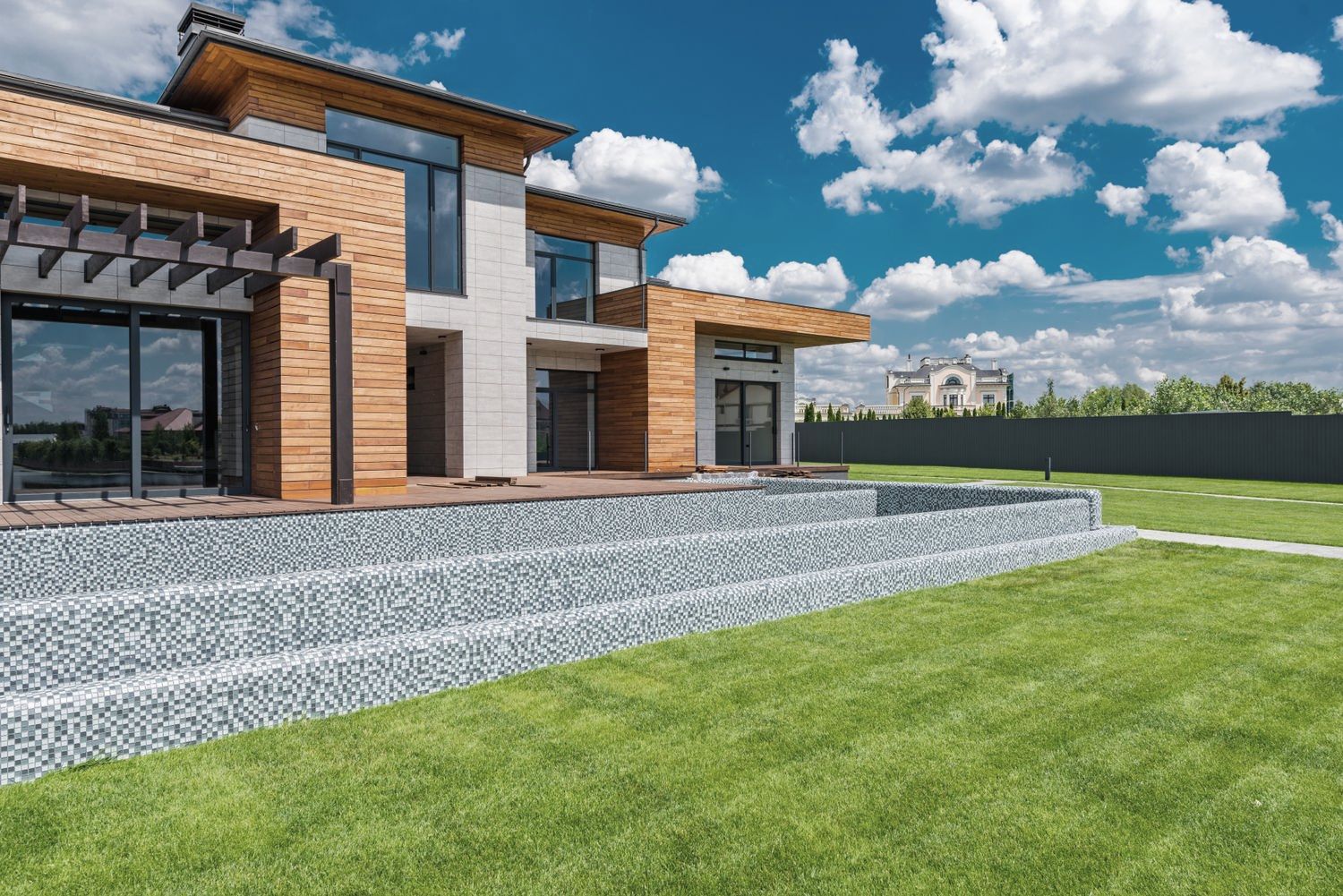 Larch-clad house with full-height glazing opening onto a wide lawn