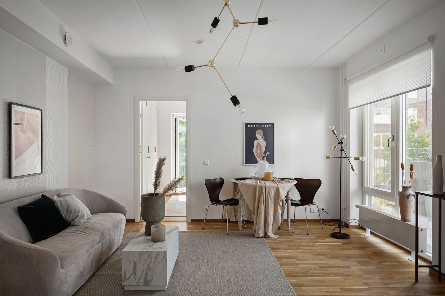 Bright living room with oak floors and tall windows in a converted warehouse flat